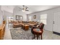 Bright and airy living room featuring a large sectional sofa, modern ceiling fan and hardwood floors at 24108 N Nectar Ave, Florence, AZ 85132