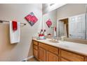 Neutral bathroom featuring a wood vanity, decorative art and a large mirror at 2571 E Balsam Ct, Chandler, AZ 85286