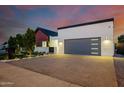 A modern home with a spacious driveway, contemporary garage door, and minimalist landscaping at 2643 N Fiesta St, Scottsdale, AZ 85257