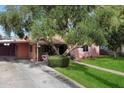 Charming home featuring mature trees, a lush green lawn, and a well-maintained exterior at 2942 E Mulberry Dr, Phoenix, AZ 85016