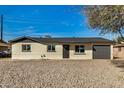 The exterior of the home is painted with light colors and dark accents to match the roof and the garage door at 3034 W San Miguel Ave, Phoenix, AZ 85017