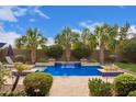 Backyard pool with waterfalls, paver deck, and tropical landscaping at 3881 E Birchwood Pl, Chandler, AZ 85249