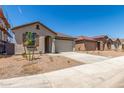 Street view of single story homes with concrete driveways and landscaped yards at 3906 N 103Rd Ave, Avondale, AZ 85392