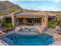 Backyard view of a private pool with stone accents and outdoor seating area with beautiful desert views at 42237 N 107Th Pl, Scottsdale, AZ 85262