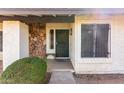 Close-up of front door, featuring a stone accent wall and a secure metal gate at 4401 W Lewis Ave, Phoenix, AZ 85035