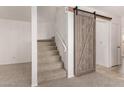 Carpeted staircase with decorative barn door and white railing for a contemporary design at 5808 E Brown Rd # 110, Mesa, AZ 85205