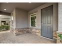 Covered front porch with stone accents and a gray front door at 7057 E Diamond St, Scottsdale, AZ 85257