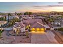 Aerial view of a beautiful home with a tile roof and well-manicured landscaping at sunset at 815 E County Down Dr, Chandler, AZ 85249