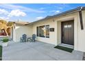 Inviting front porch with seating, a black front door, and manicured landscaping at 8215 E Cypress St, Scottsdale, AZ 85257