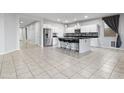 Open concept kitchen featuring white cabinets, stainless steel appliances, and a large island with seating at 864 W Blue Ridge Dr, San Tan Valley, AZ 85140