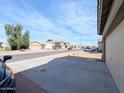 View of a street with multiple homes and cars parked in driveways, with blue skies at 8861 W Paradise Dr, Peoria, AZ 85345