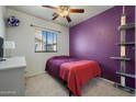 Cozy bedroom with bright purple accent wall, plush carpet and a window with natural light at 910 W Aspen Way, Gilbert, AZ 85233