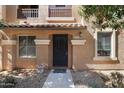 Inviting front entrance with decorative door and exterior lights and a charming balcony above at 910 W Aspen Way, Gilbert, AZ 85233