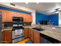 Functional kitchen with wood cabinets, granite countertops, breakfast bar and stainless steel appliances at 910 W Aspen Way, Gilbert, AZ 85233