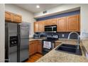 Well-equipped kitchen with stainless steel appliances, granite counters, wood cabinets and black backsplash at 910 W Aspen Way, Gilbert, AZ 85233