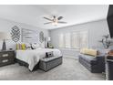 A bright and serene main bedroom featuring a cozy seating area and ample natural light at 9115 W Kimberly Way, Peoria, AZ 85382