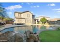 Beautiful backyard pool with waterfall feature and manicured landscaping at 925 E Doris St, Avondale, AZ 85323