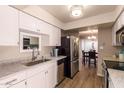 Well-lit kitchen boasts stainless steel appliances, white cabinets, and granite countertops at 9460 N 92Nd St # 119, Scottsdale, AZ 85258