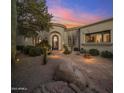 Beautiful front entrance featuring a circular foyer with a stone walkway and lush desert landscaping at 10040 E Happy Valley Rd # 289, Scottsdale, AZ 85255