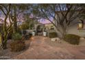 Landscaped front entrance with mature trees, tiled walkway, decorative planters, and gate providing privacy and curb appeal at 10040 E Happy Valley Rd # 289, Scottsdale, AZ 85255