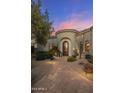 Elegant front entrance boasting a circular foyer, a wrought iron door, and manicured desert landscaping at 10040 E Happy Valley Rd # 289, Scottsdale, AZ 85255