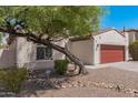 Home exterior with desert landscape and an ADT security system, featuring a red garage door at 10212 W Wier Ave, Tolleson, AZ 85353