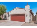 Exterior shot of the garage with red door, showing the house number and adjacent property at 10212 W Wier Ave, Tolleson, AZ 85353