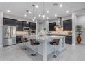 Modern kitchen featuring dark cabinetry, stainless steel appliances, granite countertops, and a large kitchen island at 10455 E Thornton Ave, Mesa, AZ 85212