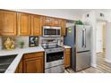 Modern kitchen featuring stainless steel appliances, light countertops, and oak cabinets at 10620 W Snead Dr, Sun City, AZ 85351