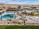 Aerial view highlighting community amenities, including a pool, playground, and lounging areas near desert landscaping at 116 N 176Th Ln, Goodyear, AZ 85338