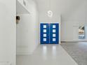 Bright foyer featuring a vibrant blue double door, sleek tile flooring, and contemporary lighting at 11942 N 95Th St, Scottsdale, AZ 85260