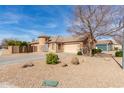 Single-Gathering home featuring a spacious driveway, desert landscaping, and unique turret architectural element at 12312 N 147Th Ln, Surprise, AZ 85379