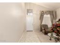 Inviting foyer with tile flooring, high ceilings, a chandelier, and a sitting chair at 12809 W Evans Dr, El Mirage, AZ 85335