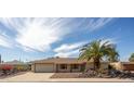 Single-story home featuring a two-car garage, desert landscaping, and a welcoming entrance at 15602 N Nicklaus Ln, Sun City, AZ 85351