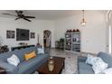 Comfortable living area with sofas, display shelving, and a ceiling fan, perfect for relaxing or entertaining guests at 17632 W Voltaire St, Surprise, AZ 85388