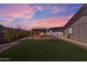 Relaxing backyard with a covered patio, a fire pit, artificial turf, and a view of the sunset at 1840 N Brighton Cir, Mesa, AZ 85207