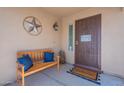 Cozy front porch with a wooden bench, pillows, and welcome mat at 1899 W Prospector Way, San Tan Valley, AZ 85144