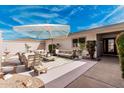 Outdoor patio with lounge seating, umbrella, and manicured landscaping perfect for relaxing or entertaining guests at 19817 N Ponderosa Cir, Sun City, AZ 85373