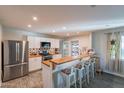 Bright kitchen featuring white cabinetry, stainless steel appliances, a butcher block breakfast bar, and decorative backsplash at 2125 W Berridge Ln, Phoenix, AZ 85015