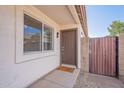 A welcoming front entrance with a neutral-colored door, a side gate, and an exterior window with light colored trim at 3043 W Melinda Ln, Phoenix, AZ 85027