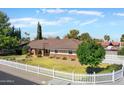 Well-maintained home with tidy landscaping, front lawn, and a classic white picket fence at 3160 E Fox St, Mesa, AZ 85213