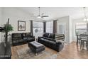 Comfortable living room with dark leather furniture, ceiling fan, and natural light at 3804 E Encinas Ave, Gilbert, AZ 85234