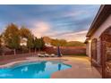 Inviting backyard pool featuring a lounge area, desert landscaping, and mountain views at 39610 N 12Th St, Phoenix, AZ 85086