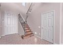 Bright entryway with tile flooring, a staircase with iron railing, and neutral paint at 42829 N Livingstone Way, Anthem, AZ 85086