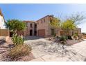 Expansive beige home featuring a desert landscape with multiple garages and concrete driveway at 42829 N Livingstone Way, Anthem, AZ 85086