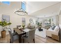 Bright dining area featuring hardwood floors, modern chandelier, and an open-concept layout at 43819 W Wolf Dr, Maricopa, AZ 85138