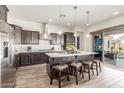 Modern kitchen with stainless steel appliances, island with seating and sliding doors to the backyard at 4684 N 206Th Ave, Buckeye, AZ 85396