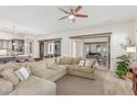 Bright and airy living room with a large sectional sofa, ceiling fan, and access to the backyard at 4684 N 206Th Ave, Buckeye, AZ 85396