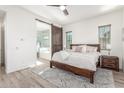 Serene main bedroom features a king bed, ensuite bathroom with a soaking tub, and wood-look floors at 4684 N 206Th Ave, Buckeye, AZ 85396