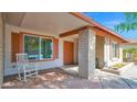 Inviting front porch with rocking chair, decorative brick pillar, and charming front door at 5216 W Beryl Ave, Glendale, AZ 85302